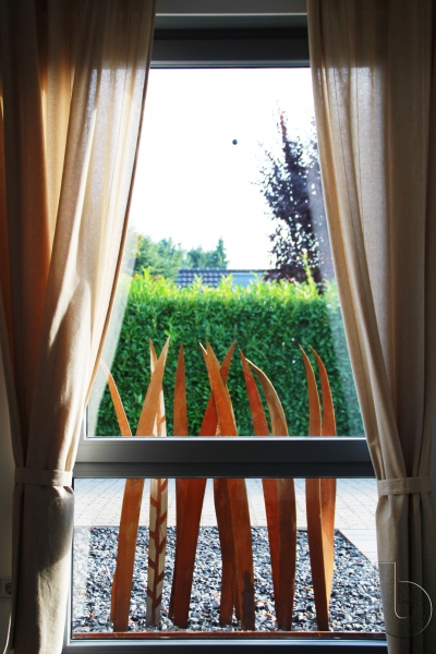Cortenstahl Grashalme vor Fenster von Innen